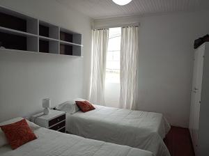 拉日什Rosário Guest House的一间卧室设有两张床和窗户。