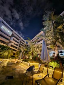 开罗Sheraton Ocean 808 - Private Apartments的酒店拥有椅子和遮阳伞,并种植了棕榈树