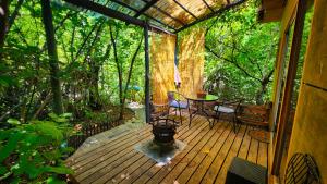 圣阿方索El Jardin, Eco Cabañas Boutique的小屋的门廊配有桌椅