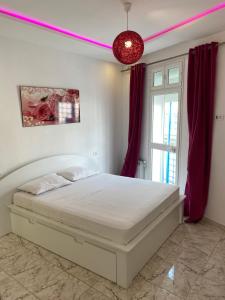 突尼斯Appartement coeur de ville Tunis的卧室配有白色的床和红色窗帘