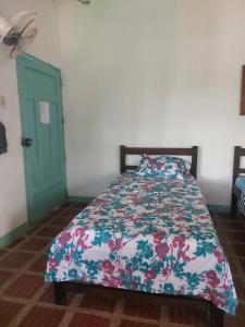 圣玛尔塔Cabaña Ecoturismo Los Mangos的一间卧室配有一张带花卉棉被的床
