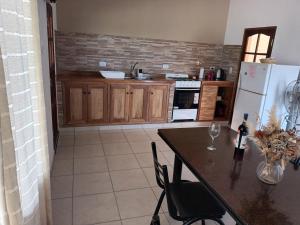 卡法亚特La Justina - Alquiler Temporario的厨房配有桌椅和冰箱。