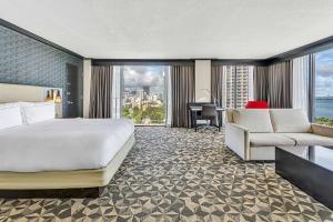 迈阿密迈阿密市区希尔顿酒店的酒店客房配有一张床、一张书桌和一张沙发。