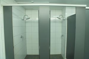 墨尔本墨尔本市背包客旅舍的浴室设有2个带玻璃门的淋浴间