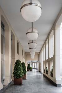 帕多瓦Hilton Garden Inn Padova City Centre的建筑里带有盆栽和灯的走廊