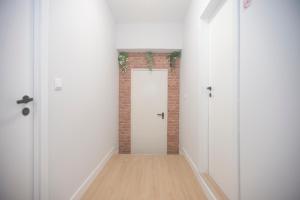 MoreiraAerostay Hostel的一条空的走廊,有白色的门和砖墙