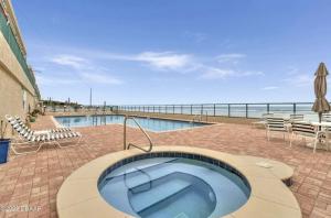庞塞进Ponce Inlet Florida Breathtaking Oceanfront Penthouse Villa!的毗邻大海的带热水浴池的游泳池