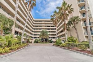 庞塞进Ponce Inlet Florida Breathtaking Oceanfront Penthouse Villa!的一座棕榈树环绕的大建筑