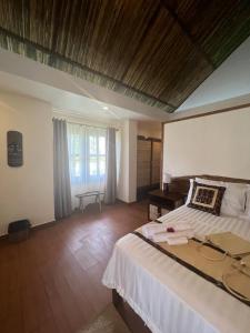 布桑加San Nicolas Private Beach的一间卧室配有一张床、一张书桌和一个窗户。