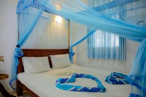 蒂瑟默哈拉默New Cormorant Lake Resort & Yala Safari Place的一间卧室配有一张蓝色窗帘的床