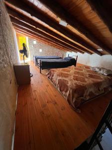 Las CompuertasTu rincón la travesia的一间卧室设有一张大床,铺有木地板