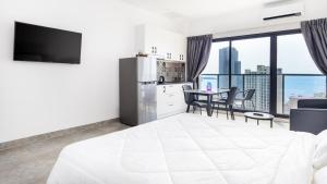 西哈努克AIR APARTMENTS Residence - Sihanoukville - 400m to boat pier的一间带白色床的卧室和一间享有美景的厨房