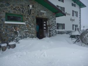 佩里舍峡谷Peer Gynt Ski Lodge的建筑物前的雪覆盖的院子