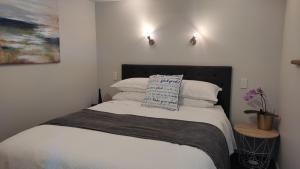 WaitarereCoastal Condo的一间卧室配有带白色床单和枕头的床。