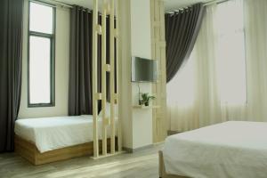 胡志明市Khách sạn Phước Lộc Thọ 2 - 福禄寿的一间卧室配有两张床和一台平面电视