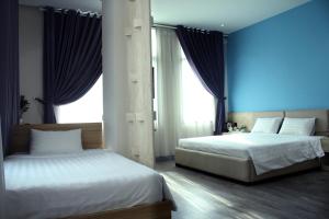 胡志明市Khách sạn Phước Lộc Thọ 2 - 福禄寿的卧室设有两张床铺,拥有蓝色的墙壁和窗户