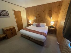 佩里舍峡谷Peer Gynt Ski Lodge的一间卧室配有一张大床,两台桌子上放着两盏灯