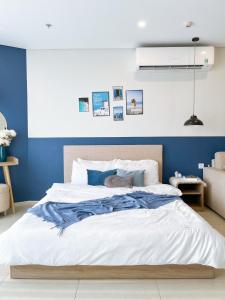 头顿CONDOTEL 5 SAO THE SÓNG VŨNG TÀU Mr VUONG的一间卧室配有一张带蓝色墙壁的大床