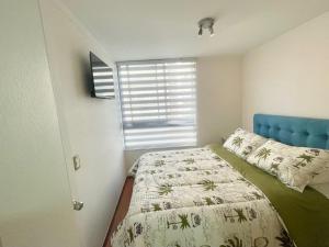圣地亚哥Casa de Moneda Downtown的一间卧室配有一张带蓝色床头板的床和窗户