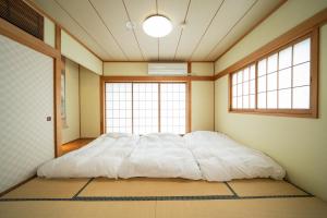 高岛市Biwa Galaxy的一张大床,位于带两个窗户的房间