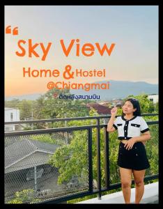 清迈Sky View Home and Hostel Chiangmai的站在阳台上喝一杯酒的女人