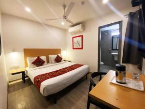新德里Hotel Diamond Tree at Pitampura的酒店客房设有床、桌子和电视。