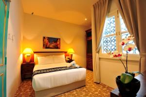 马六甲卡皮坦会馆精品酒店的一间卧室设有一张床和一个窗口