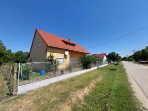 鲍洛通拜雷尼schönes Ferienhaus mit grossem Pool 1200 m zum Balaton的街道边有栅栏的房子