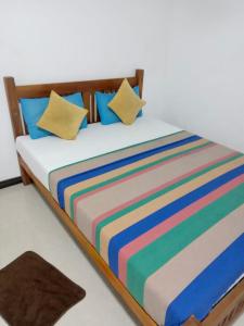 卡卢特勒River Paradise的一张带彩色条纹床单和枕头的床