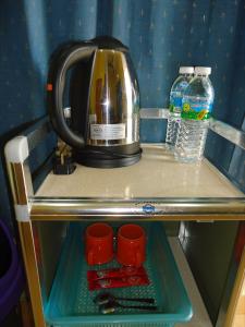 瓜拉大汉D'pinggir Guest Room的架子上的咖啡壶,上面有杯子和水