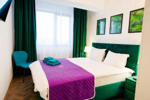 雅西Luxury Lazar Towers Palas Mall Area的一间卧室配有一张带紫色毯子的床