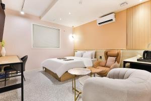 仁川市Brown Dot Hotel Incheon Jakjeon的酒店客房配有一张床、一张沙发和椅子。