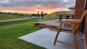 罗托鲁瓦A stunning retreat in Rotorua!的房屋一侧的木甲板上设有长凳