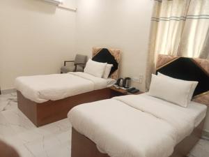 新德里Hotel Fortune Residency的酒店客房,配有两张带白色床单的床