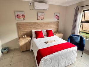 雾观Numbigate Resort & Conference的一间卧室配有一张带红色枕头的大床