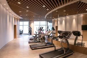 杭州杭州拱墅假日酒店的一间健身房,里面设有一排跑步机和椭圆机