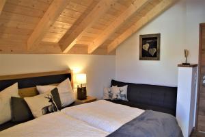 奥伊-米特尔贝格Alpenchalet Allgäu的一间卧室设有一张大床和木制天花板