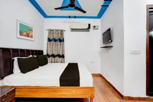 兰纳加OYO Premier Jim Corbett Home Stay的一间卧室配有一张带吊扇的床