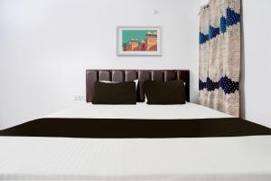 兰纳加OYO Premier Jim Corbett Home Stay的一间卧室配有一张带黑白色床罩的床。