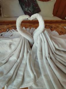 爱妮岛CHIBEL SUMMER RIVERSIDE HOTEL的两个天鹅在床上心跳