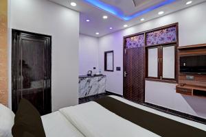 新德里OYO HOTEL MOUNT PALACE的一间卧室配有床、水槽和镜子