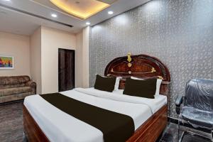新德里OYO HOTEL MOUNT PALACE的一间卧室配有一张大床和一张沙发