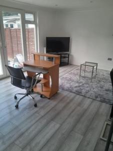 伦敦The w3 flat的办公室,配有桌子、椅子和电视
