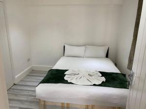 伦敦The w3 flat的卧室配有一张带绿毯的白色床