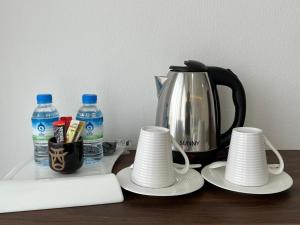 Ban KhouaphanRemember Hotel的茶壶、桌子上的杯子和瓶装水