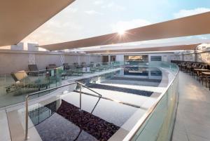 多哈多哈皇冠假日酒店 - 商业公园的大楼内带桌椅的室内游泳池