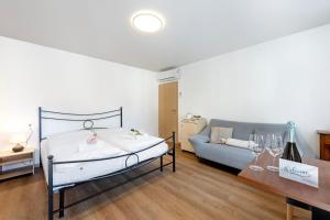CavergnoCasa Al Torchio 1,2,3 and 4 - Happy Rentals的一间卧室配有一张床和一张沙发