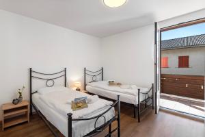 CavergnoCasa Al Torchio 1,2,3 and 4 - Happy Rentals的带窗户的客房内的两张床