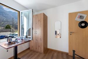 CavergnoCasa Al Torchio 1,2,3 and 4 - Happy Rentals的客房设有木桌和窗户。