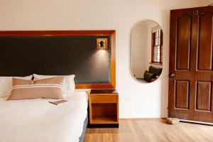 威斯曼菲瑞Wisemans Retreat的一间卧室配有一张大床和镜子